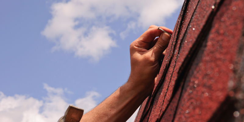 Hand nailing tiles to roof.