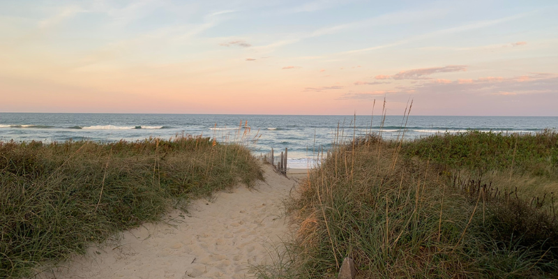Image of the beach via a beach access at sunset.