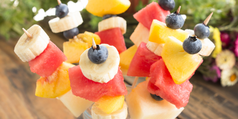 Beach Snacks - Fresh Fruit Skewers Beach Snacks - Fresh Fruit Skewers; Image of watermelon, peaches, bananas, and blueberries on wooden sticks.